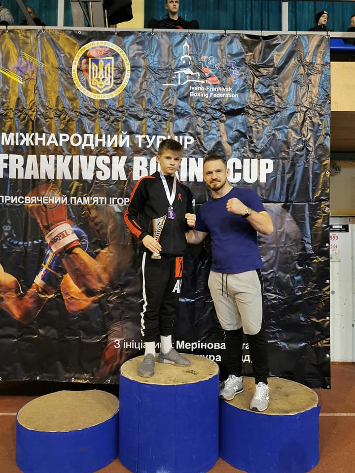 Młody Artur z medalem na podium z ojcem Grzegorzem